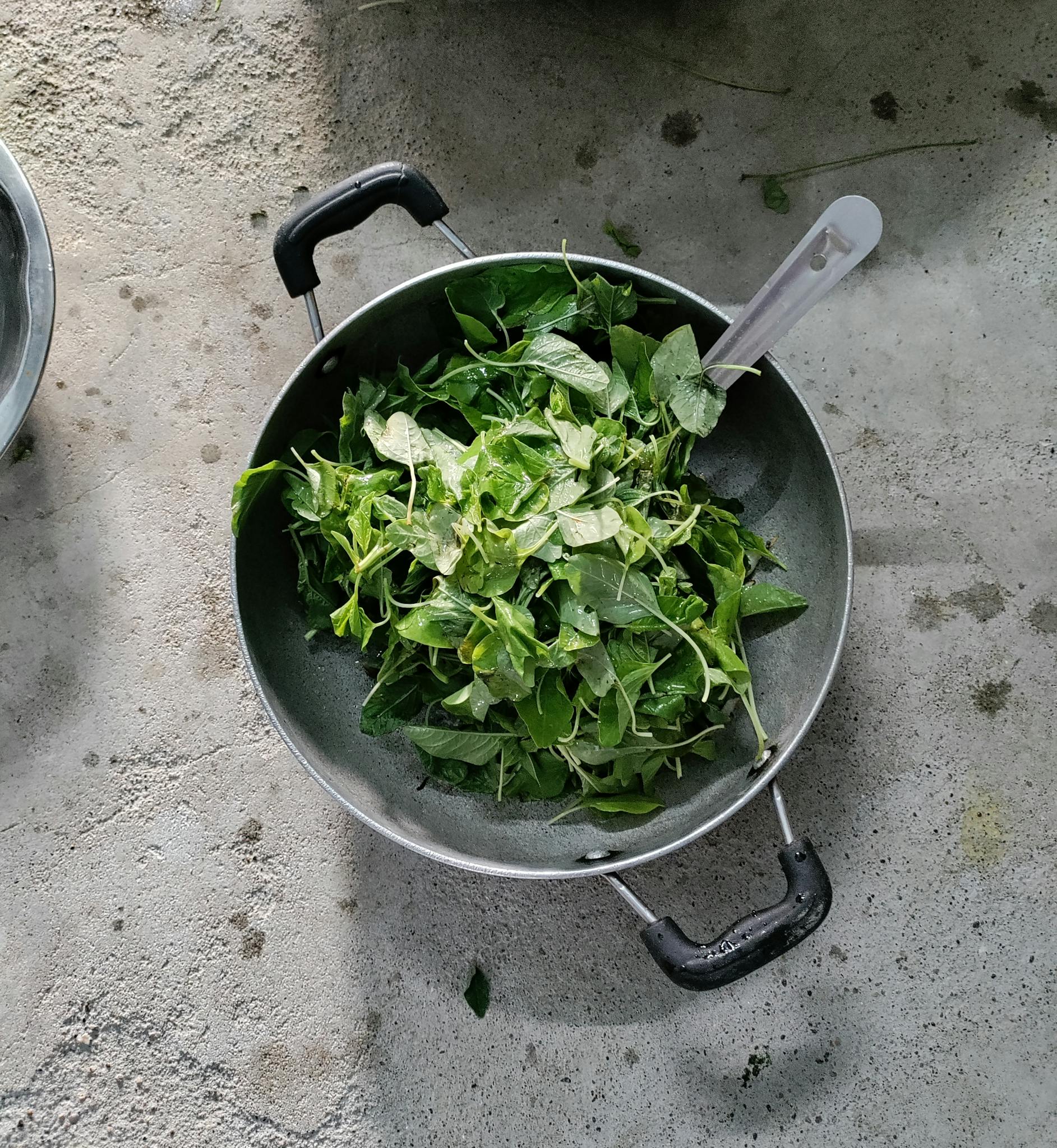 High-angle view of fresh spinach leaves in a pan, perfect for healthy cooking themes.